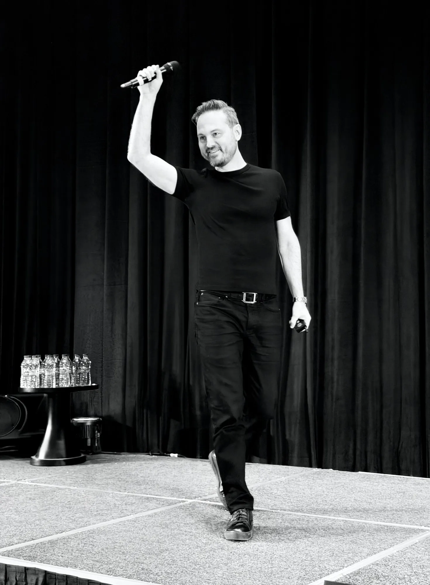 Jesse Schoberg on stage holding a microphone at MicroConf in Istanbul